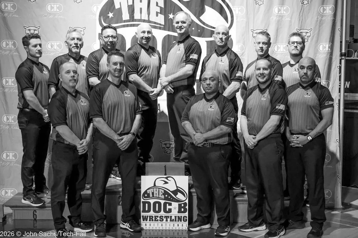 Wrestling officials together in front of a Doc B Wrestling backdrop.